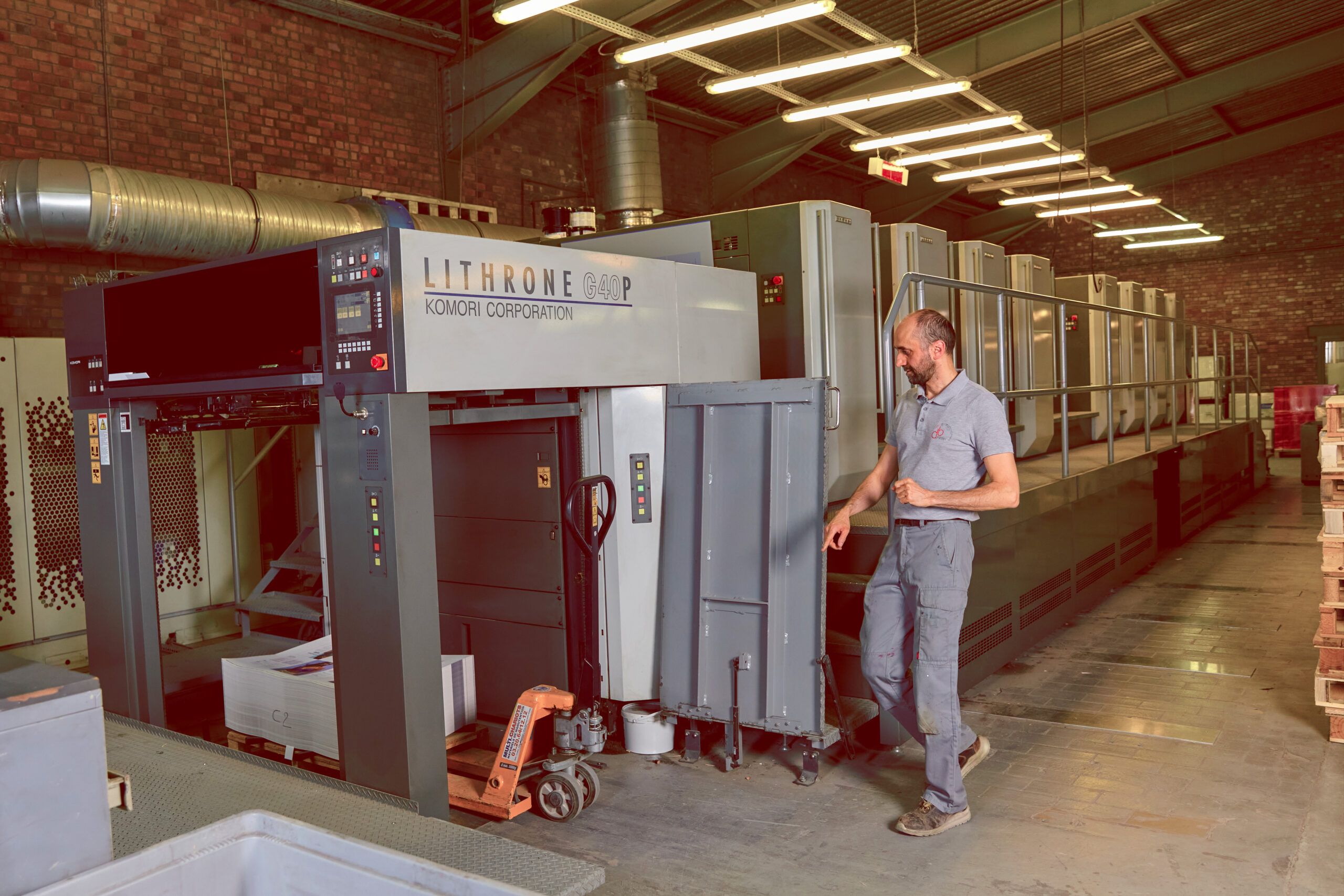 Opérateur de l'imprimerie  DBPrint France travaillant sur une machine d'impression par rotogravure.